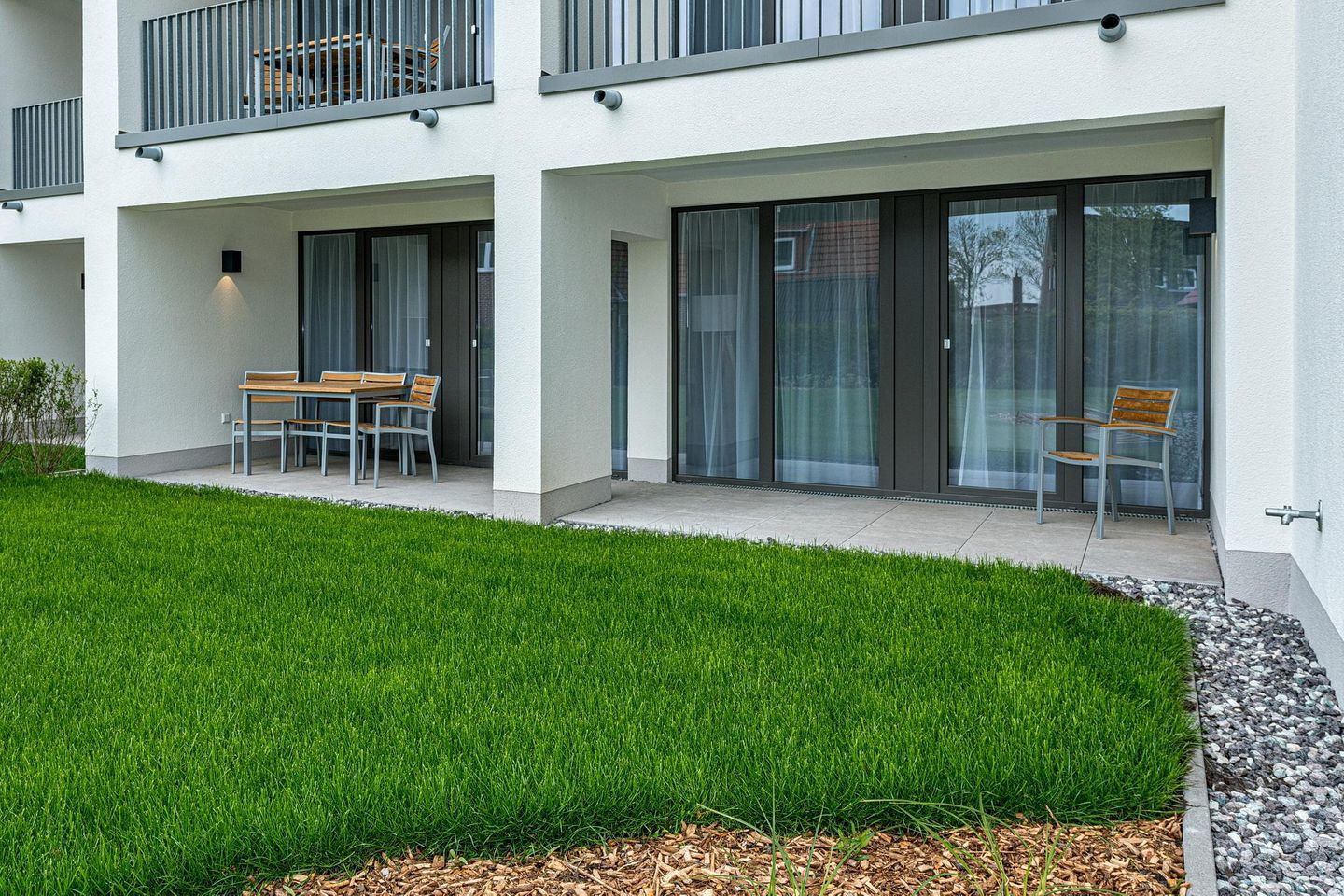 Deichhäuser Anna Küste Deichhäuser Anna Küste 8-13 Bensersiel - Überdachte Terrasse mit Sitzgelegenheit und Grünfläche