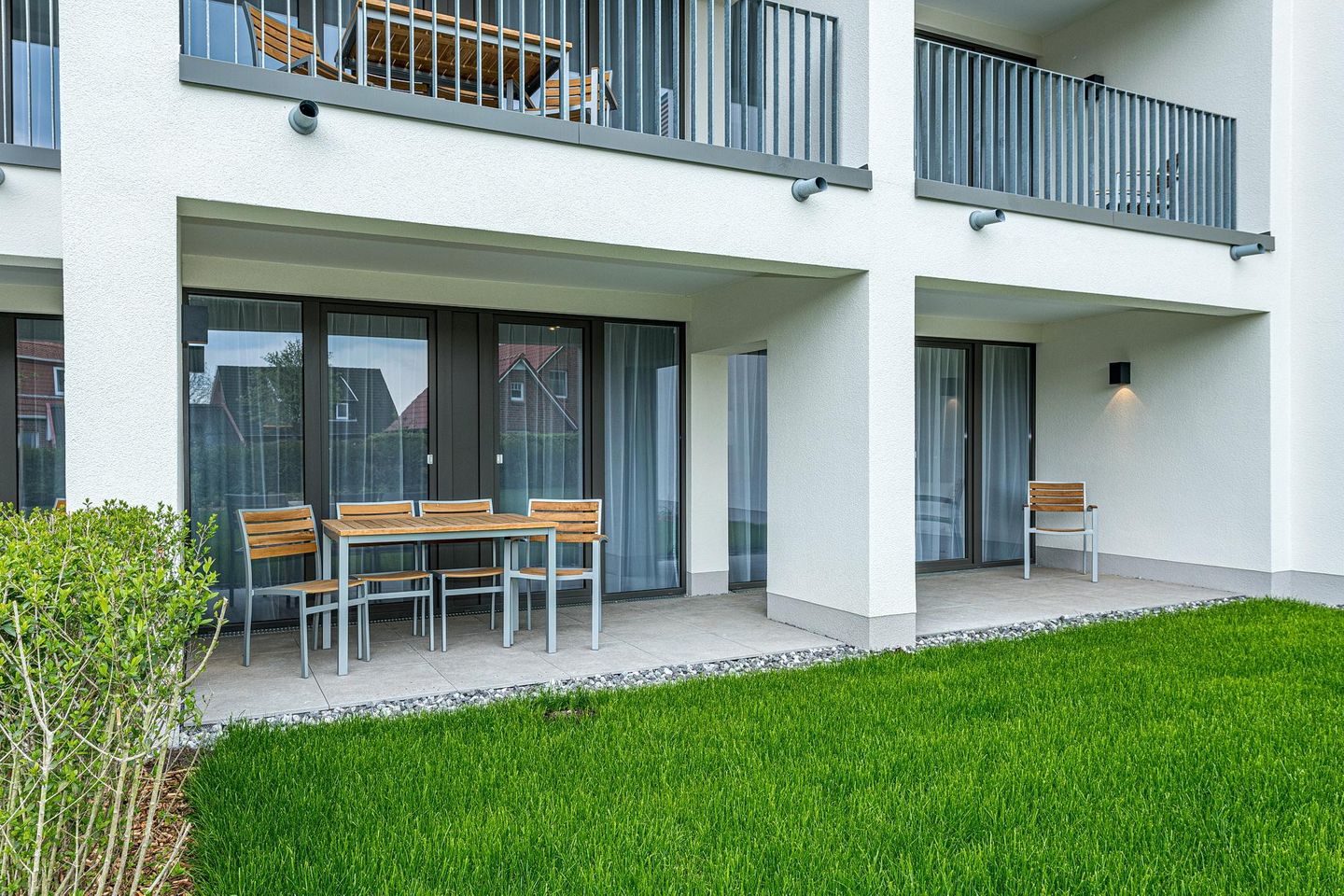 Deichhäuser Anna Küste Deichhäuser Anna Küste 8-13 Bensersiel - Überdachte Terrassen mit Sitzgelegenheit und Grünfläche