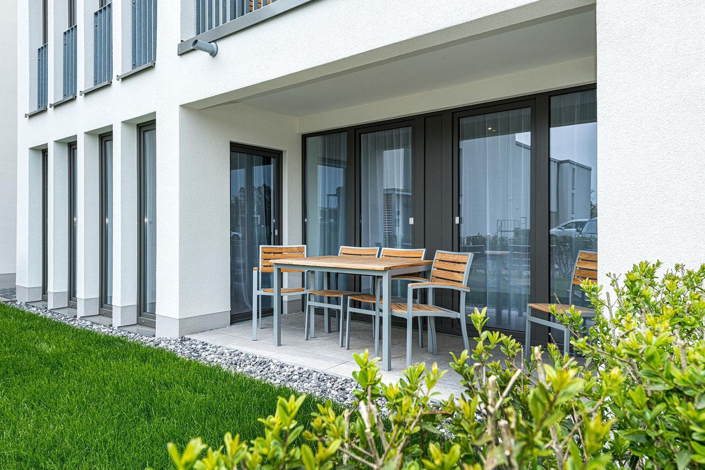 Deichhäuser Anna Küste Deichhäuser Anna Küste 8-14 Bensersiel - Überdachte Terrasse mit Sitzgelegenheit und Grünfläche