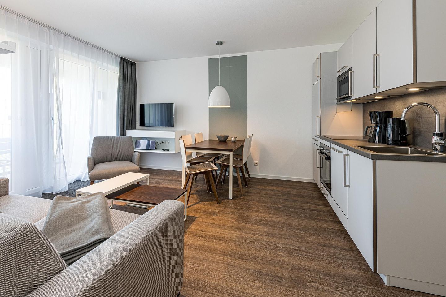 Deichhäuser Anna Küste Deichhäuser Anna Küste 8-21 Bensersiel - Wohn-Essbereich mit Couch und Küchenzeile