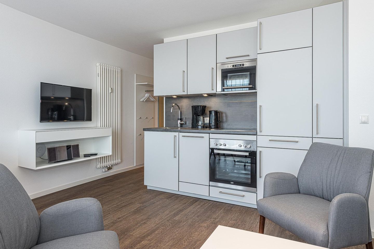 Deichhäuser Anna Küste Deichhäuser Anna Küste 8-33 Bensersiel - Wohn-Essbereich mit Couch und Küchenzeile