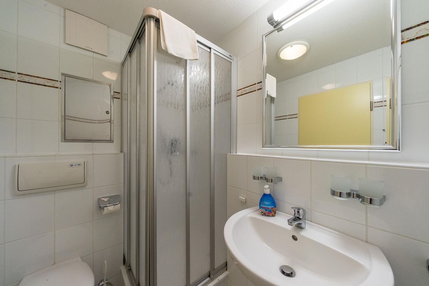 Hus Inselkieker Hus Inselkieker 221 Schillig - Badezimmer mit Dusche, WC, Waschtisch und Spiegel