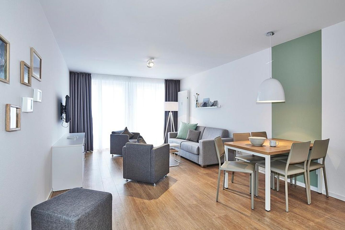 Deichhäuser Anna Küste Deichhäuser Anna Küste 4-30 Bensersiel - Wohn-Essbereich mit Sofa, Sitzgelegenheit und Zugang zum Balkon