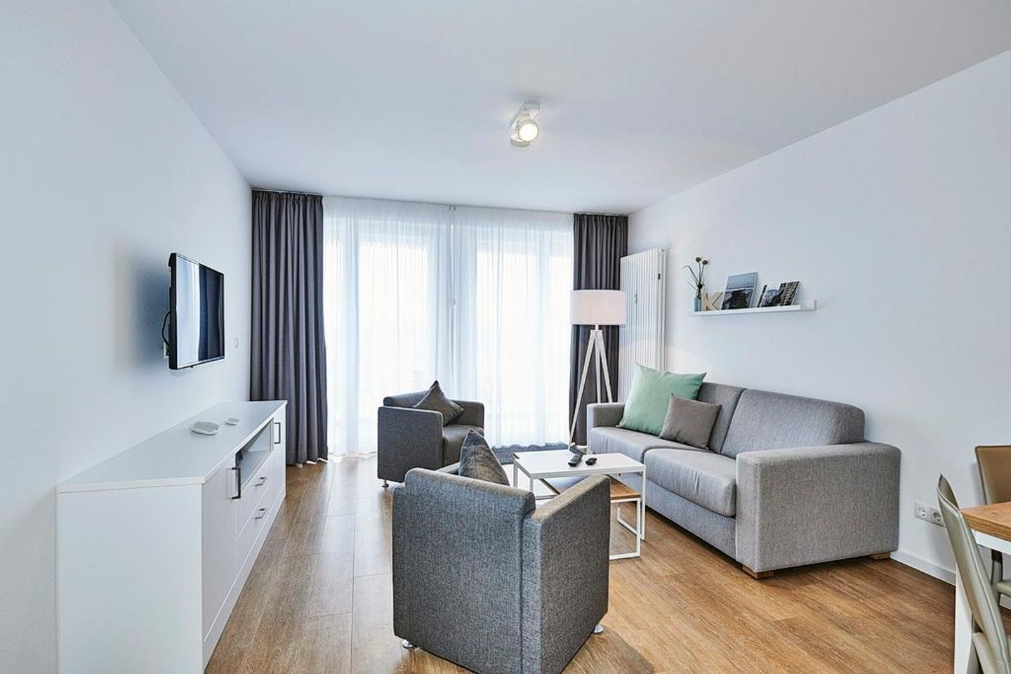 Deichhäuser Anna Küste Deichhäuser Anna Küste 4-30 Bensersiel - Wohnbereich mit Sofa, Sessel, Couchtisch und Zugang zum Balkon