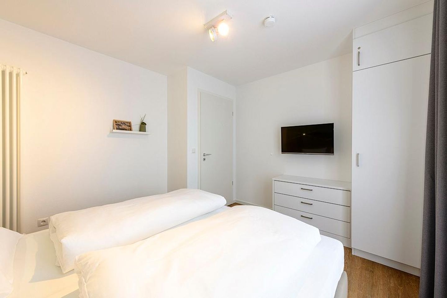 Deichhäuser Anna Küste Deichhäuser Anna Küste 1-30 Bensersiel - Schlafzimmer mit Doppelbett, Kleiderschrank und TV