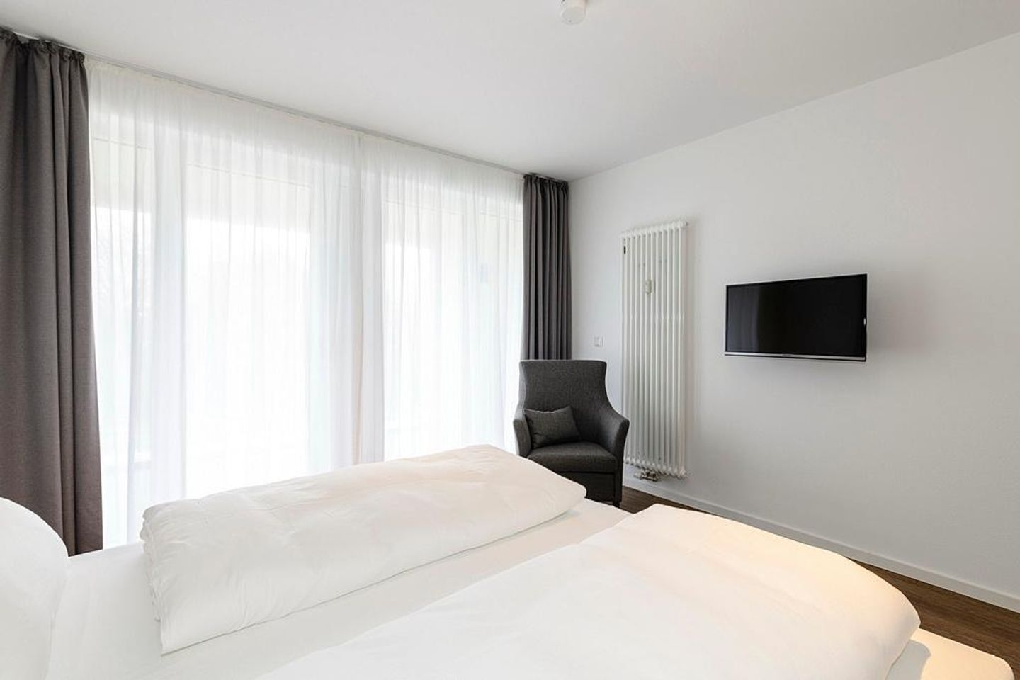 Deichhäuser Anna Küste Deichhäuser Anna Küste 1-21 Bensersiel - Schlafzimmer mit Doppelbett, Sessel und TV