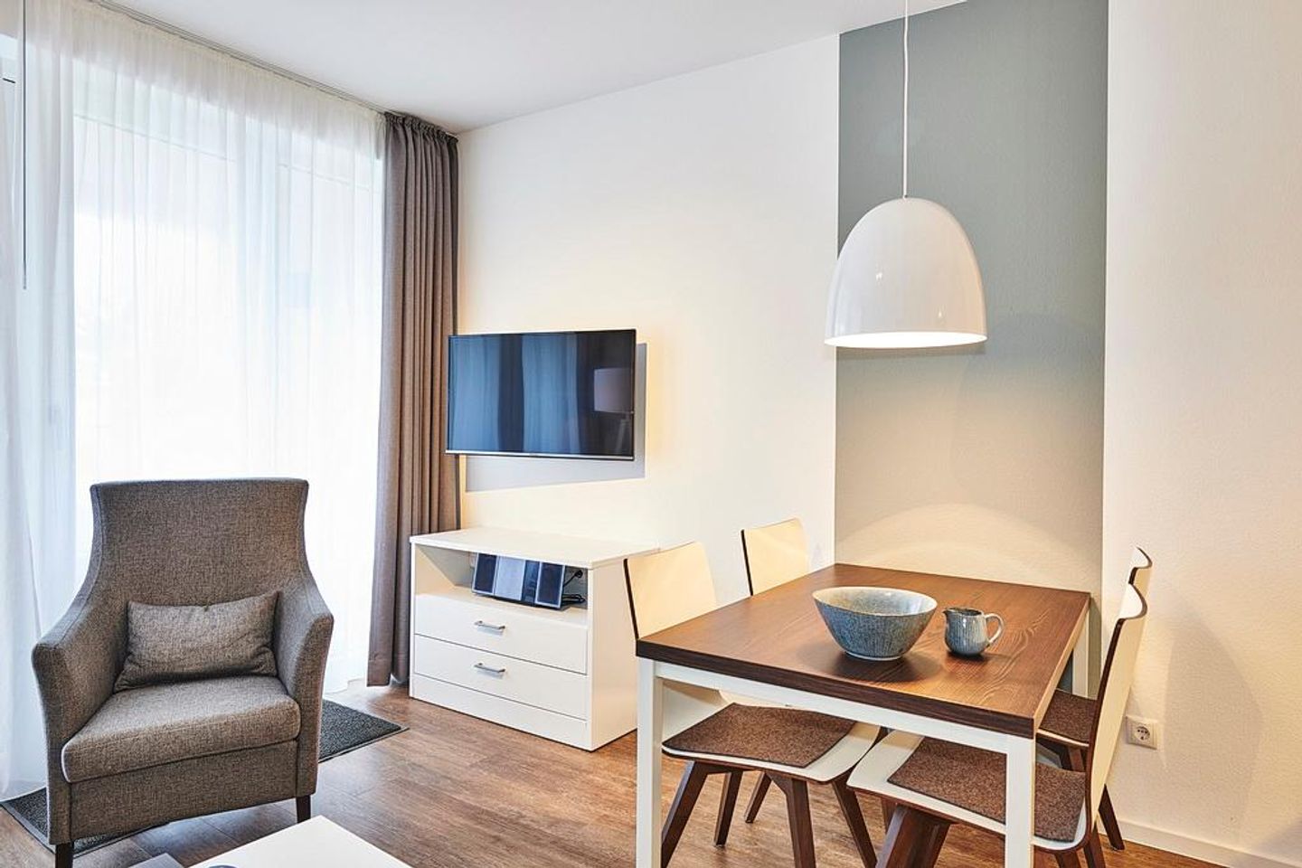 Deichhäuser Anna Küste Deichhäuser Anna Küste 2-11 Bensersiel - Wohn/Essbereich mit Sessel, Esstisch und TV