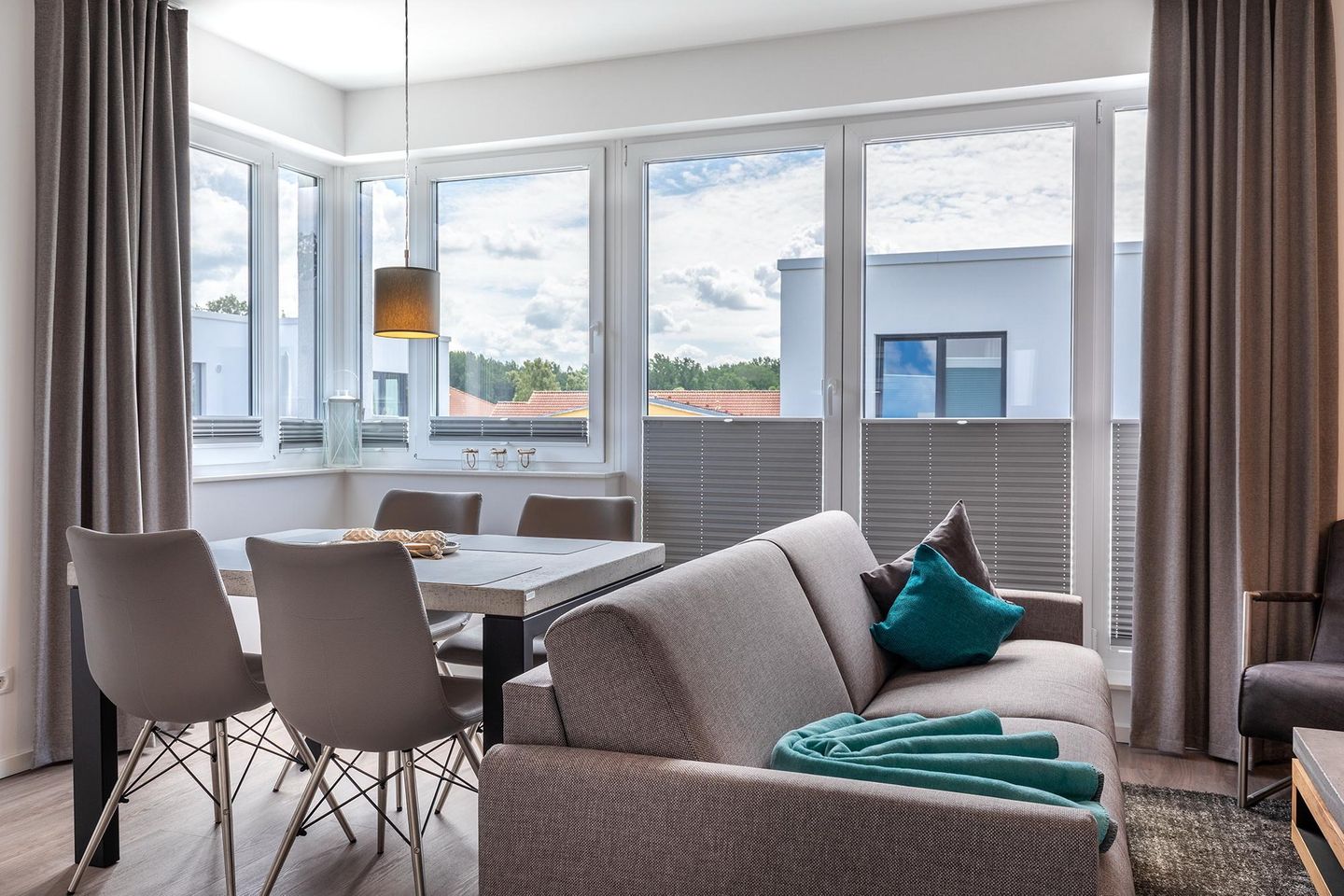 Aparthotel Ostseeallee Aparthotel Ostseeallee 2-16 Boltenhagen - Wohnbereich mit Doppelschlafcouch, Esstisch und Sitzgelegenheiten