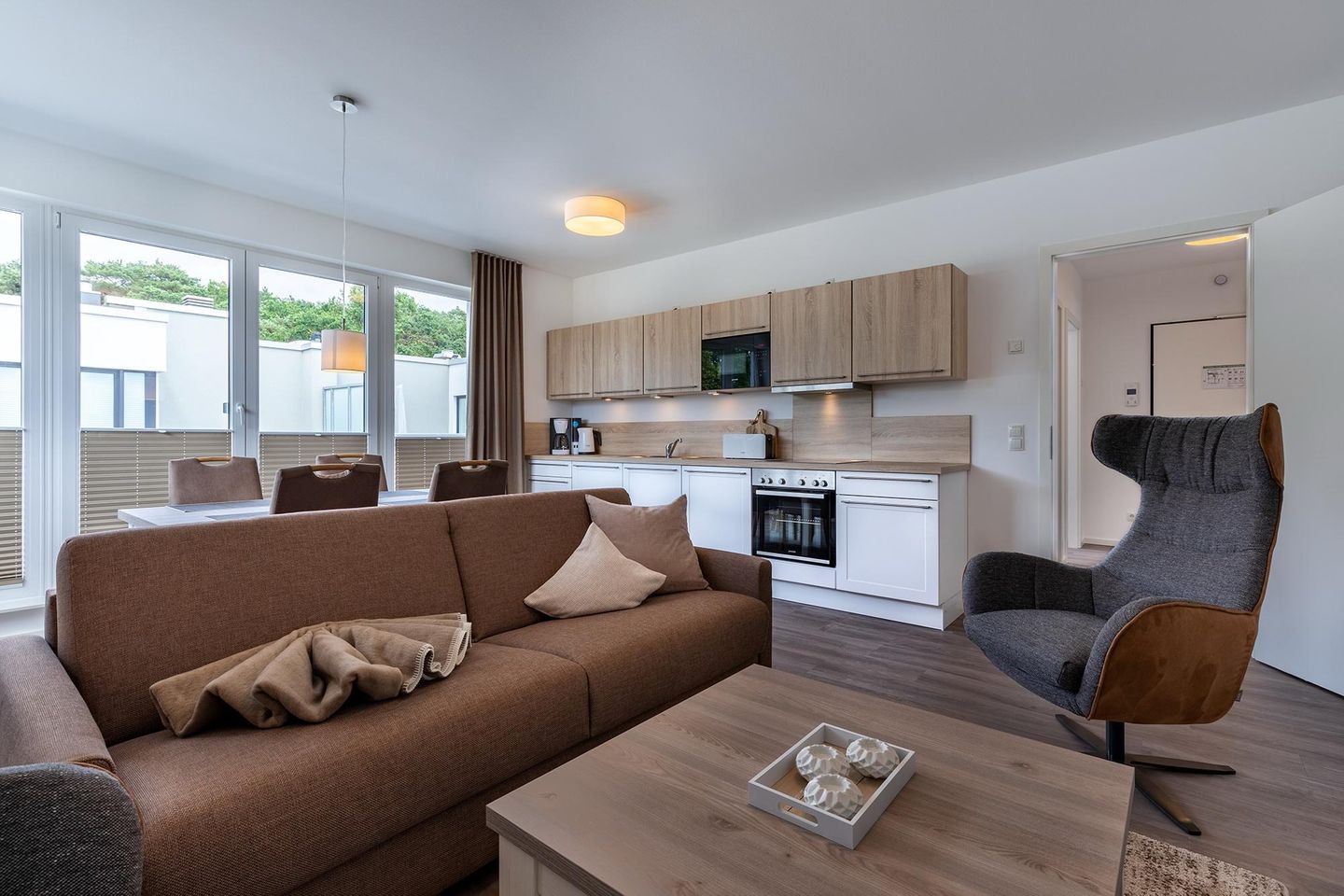 Aparthotel Ostseeallee Aparthotel Ostseeallee 2-18 Boltenhagen - Wohn-/Essbereich mit Doppelschlafcouch, Couchtisch, Sessel und Küchenzeile