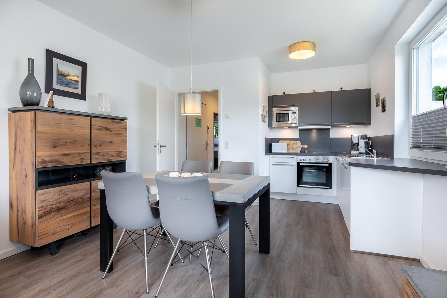 Aparthotel Ostseeallee Aparthotel Ostseeallee 3-23 Boltenhagen - Wohn-/Essbereich mit Küchenzeile, Esstisch und Sitzgelegenheiten