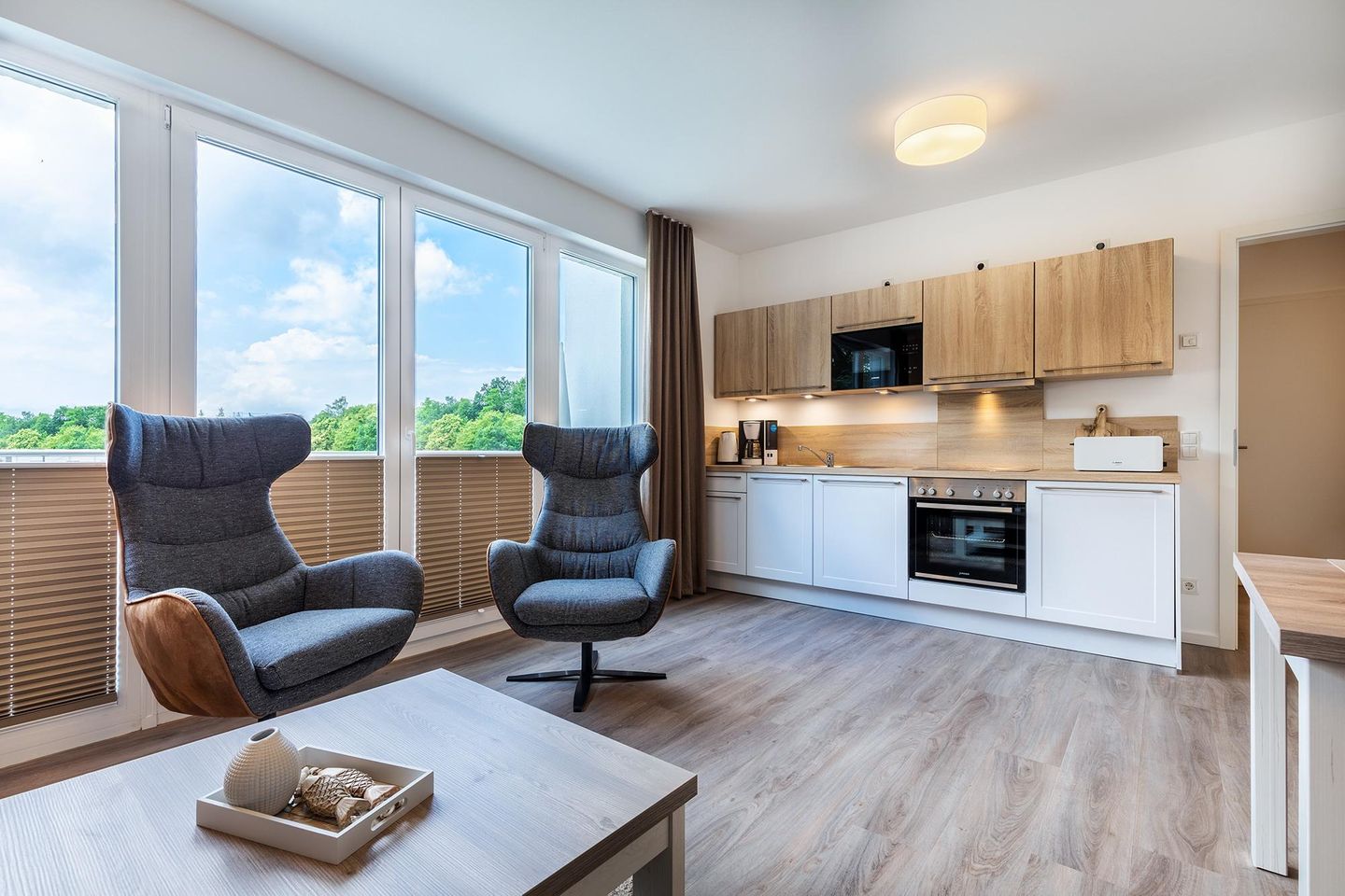 Aparthotel Ostseeallee Aparthotel Ostseeallee 3-25 Boltenhagen - Wohn-/Essbereich mit Couchtisch, Sessel und Küchenzeile