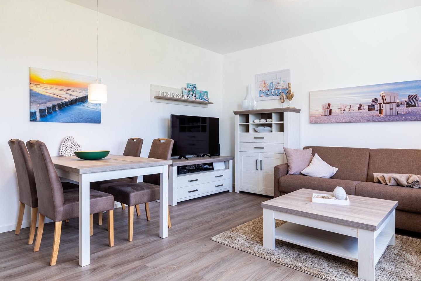 Aparthotel Ostseeallee Aparthotel Ostseeallee 3-25 Boltenhagen - Wohn-/Essbereich mit Couch, Couchtisch, TV, Esstisch und Sitzgelegenheiten