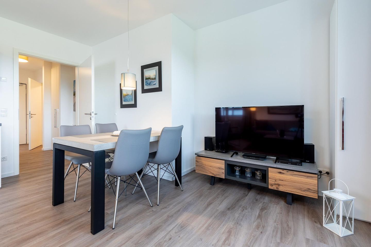 Aparthotel Ostseeallee Aparthotel Ostseeallee 3-26 Boltenhagen - Wohn-/Essbereich mit TV, Esstisch und Sitzgelegenheiten