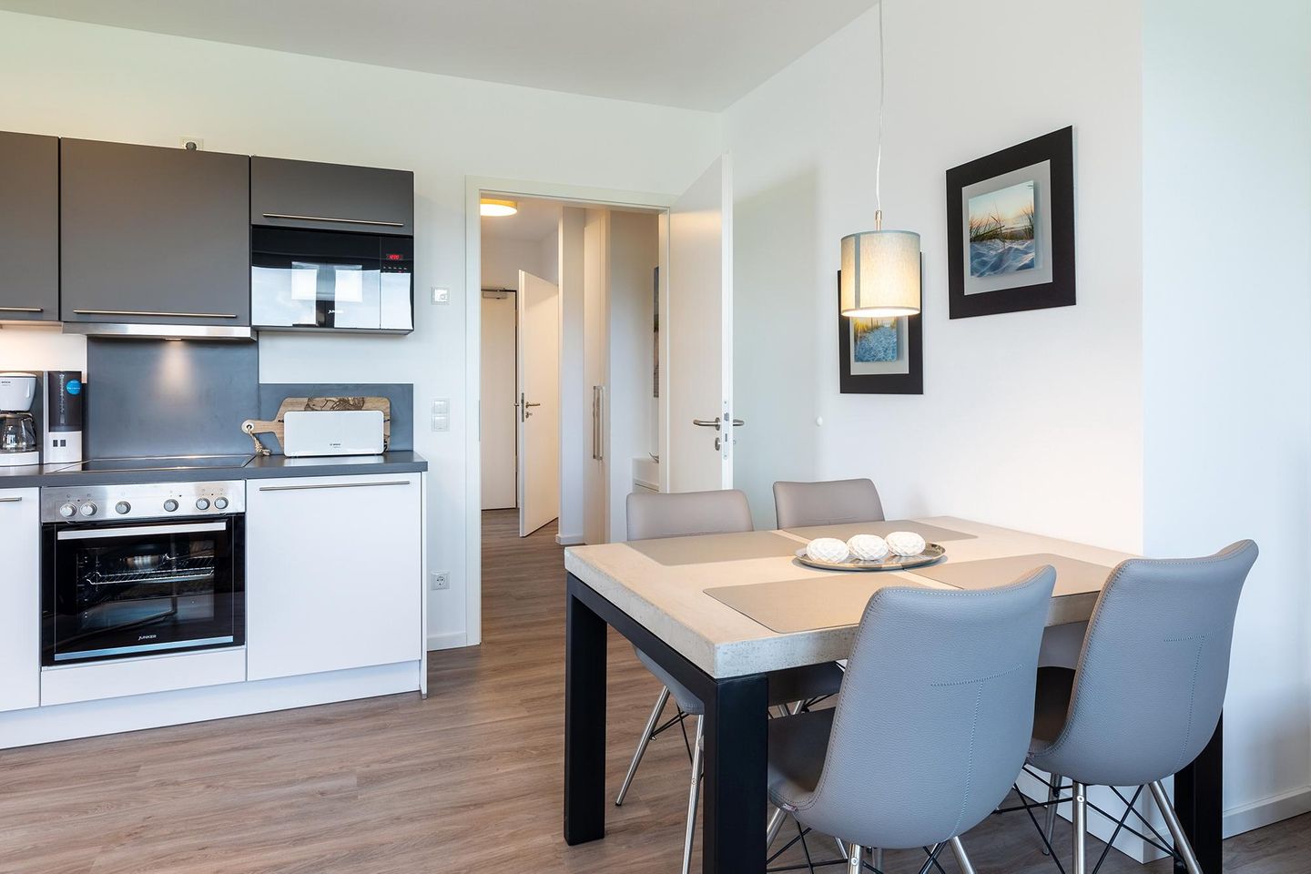 Aparthotel Ostseeallee Aparthotel Ostseeallee 3-26 Boltenhagen - Wohn-/Essbereich mit Esstisch, Sitzgelegenheiten und Küchenzeile