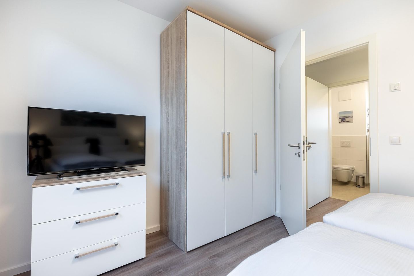 Aparthotel Ostseeallee Aparthotel Ostseeallee 3-26 Boltenhagen - Schlafzimmer mit TV, Kleiderschrank und Blick zum Badezimmer