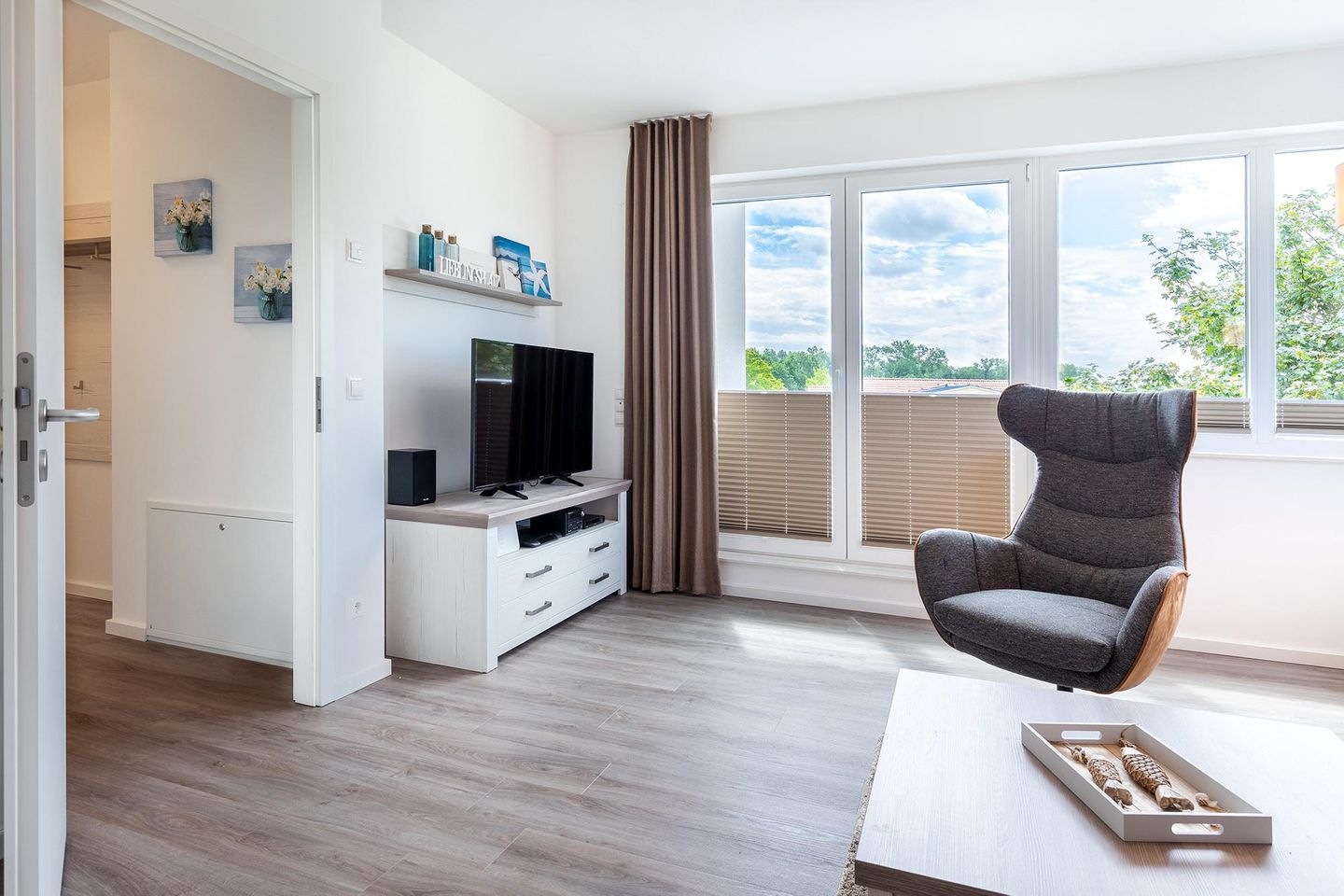 Aparthotel Ostseeallee Aparthotel Ostseeallee 3-28 Boltenhagen - Wohn-/Essbereich mit Sessel, TV und Zugang zur Dachterrasse