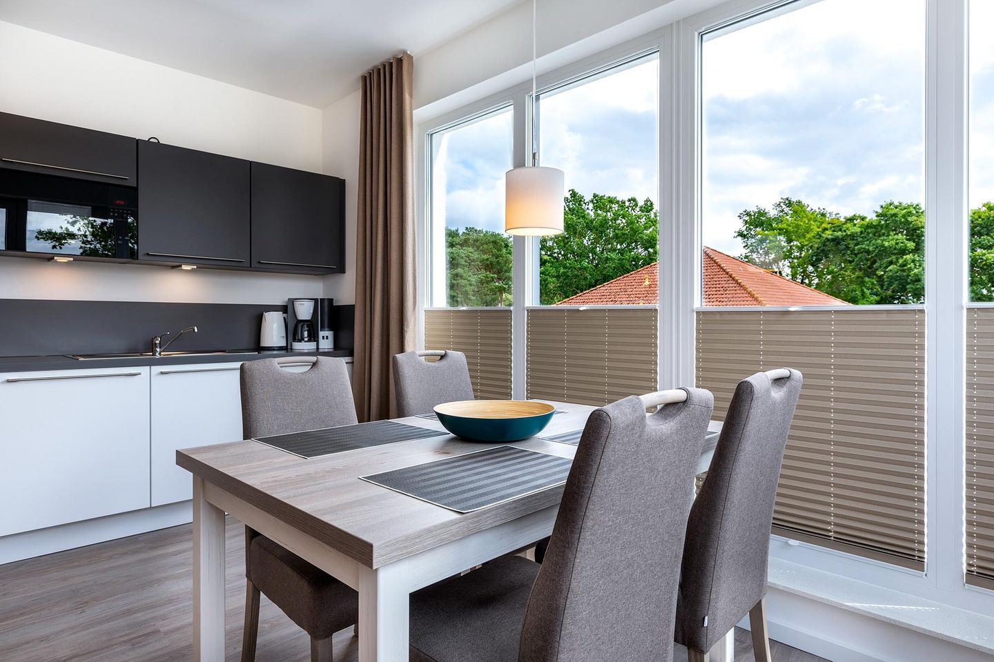 Aparthotel Ostseeallee Aparthotel Ostseeallee 4-37 Boltenhagen - Wohn-/Essbereich mit Tisch, Sitzgelegenheiten und Küchenzeile