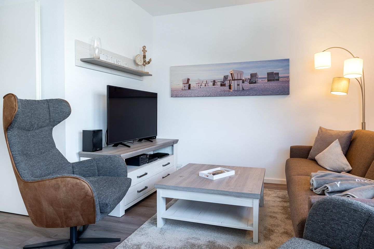 Aparthotel Ostseeallee Aparthotel Ostseeallee 4-39 Boltenhagen - Wohn-/Essbereich mit Doppelschlafcouch, Couchtisch, Sessel und TV