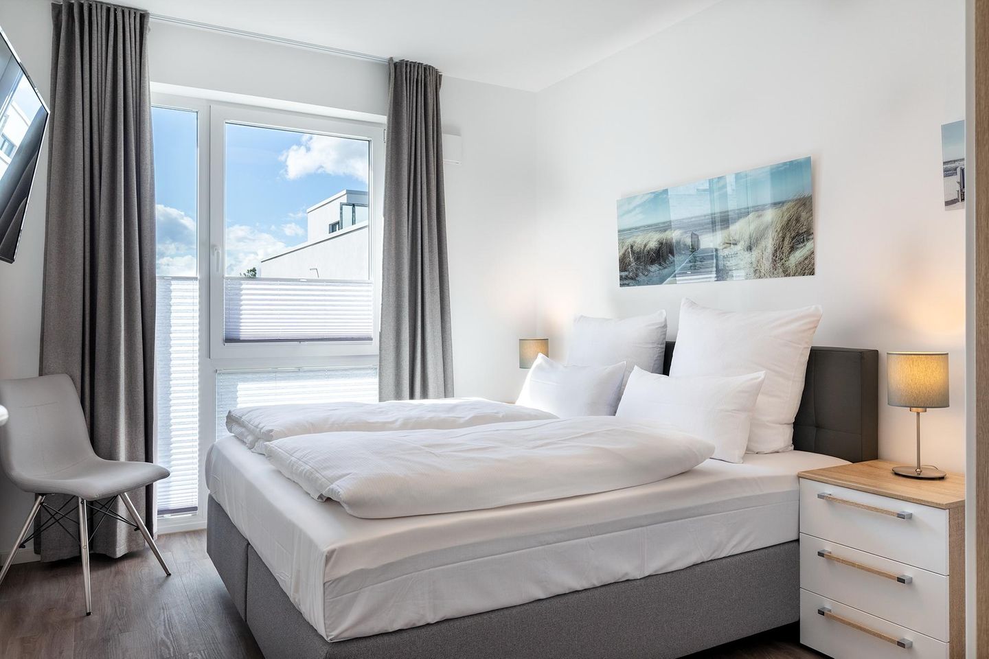 Aparthotel Ostseeallee Aparthotel Ostseeallee 5-44 Boltenhagen - Schlafzimmer "2" mit Boxspringbett (1,80 x 2,00 m), TV und Stuhl