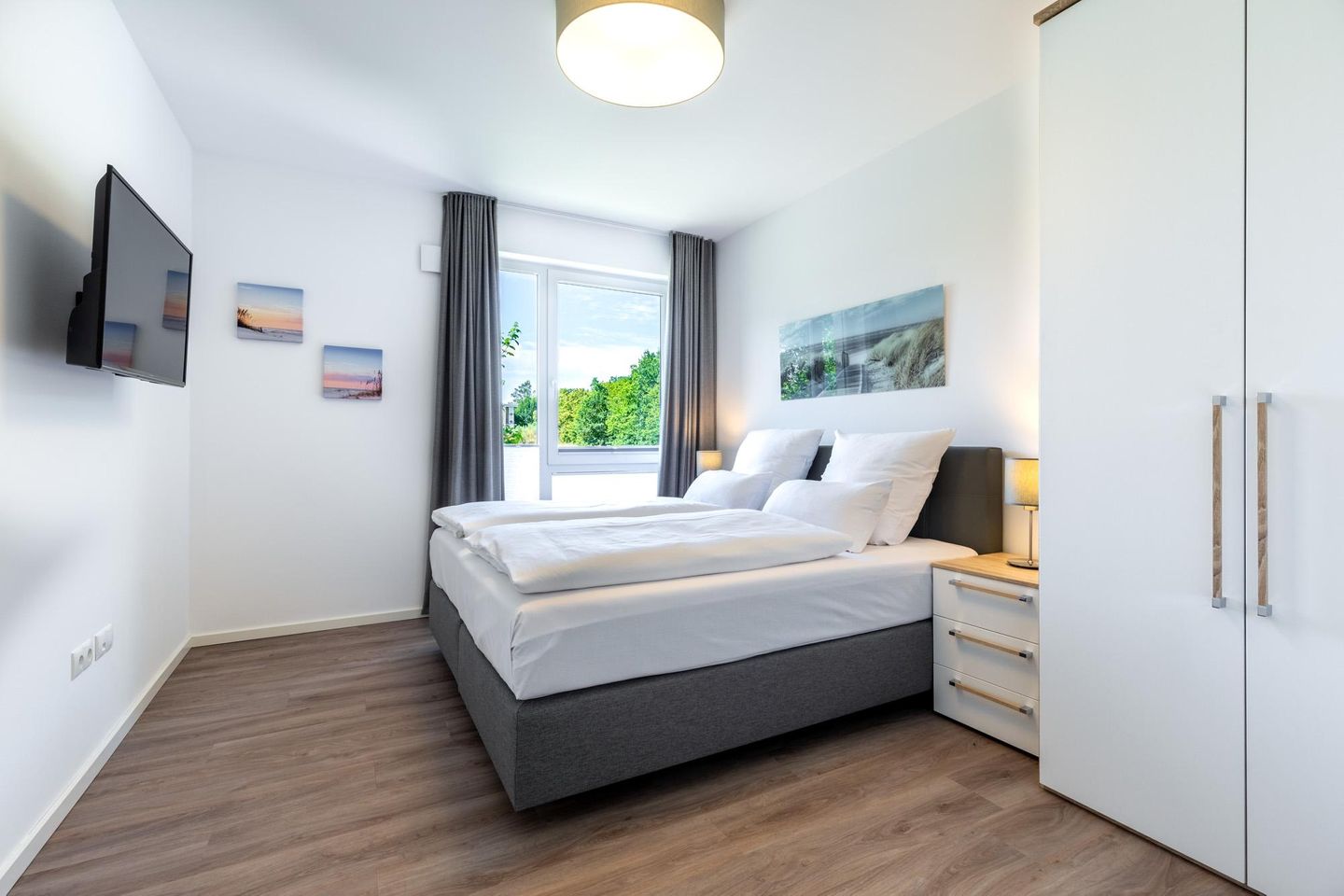 Aparthotel Ostseeallee Aparthotel Ostseeallee 2-10 Boltenhagen - Schlafzimmer mit Boxspringbett, TV und Kleiderschrank