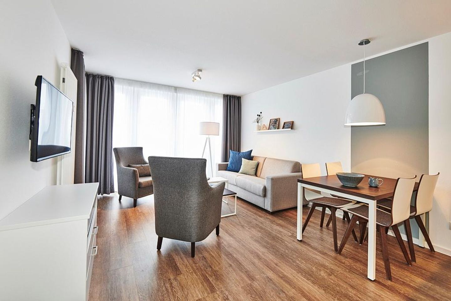 Deichhäuser Anna Küste Deichhäuser Anna Küste 2-34 Bensersiel - Wohn/Essbereich mit Sesseln, Couch, Esstisch und TV