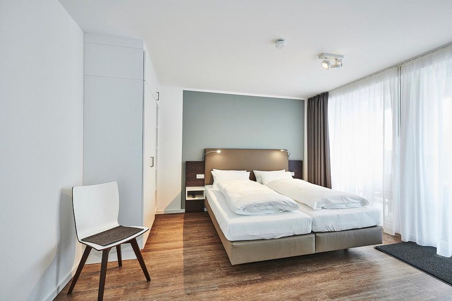 Deichhäuser Anna Küste Deichhäuser Anna Küste 2-34 Bensersiel - Schlafzimmer mit Doppelbett, Stuhl und Kleiderschrank