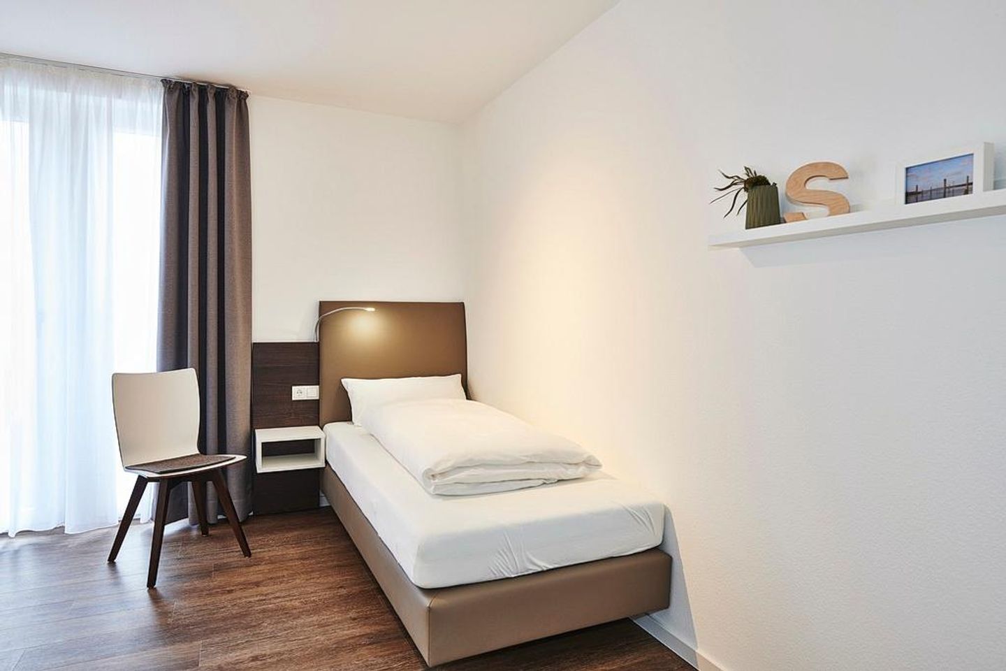 Deichhäuser Anna Küste Deichhäuser Anna Küste 2-34 Bensersiel - Schlafzimmer mit Einzelbetten und Stuhl