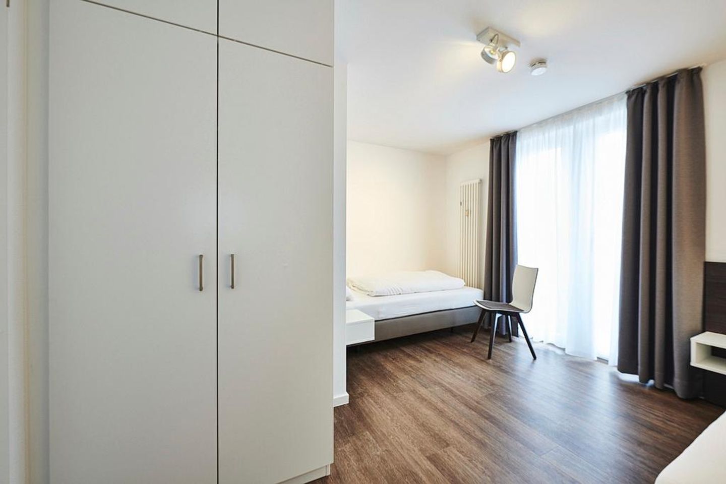 Deichhäuser Anna Küste Deichhäuser Anna Küste 2-34 Bensersiel - Schlafzimmer mit Einzelbetten, Stühlen und Kleiderschrank