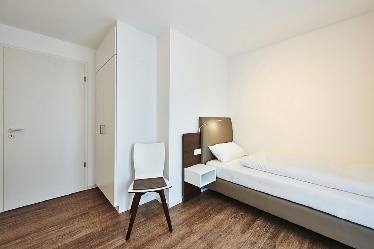 Deichhäuser Anna Küste Deichhäuser Anna Küste 2-34 Bensersiel - Schlafzimmer mit zwei Einzelbetten, Stuhl und Kleiderschrank