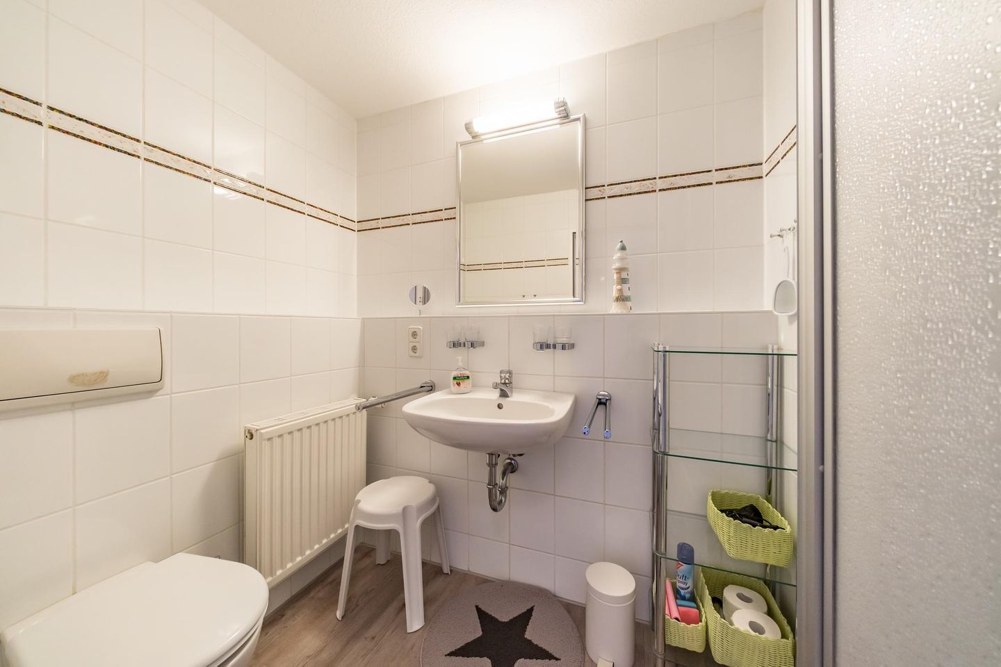 Hus Inselkieker Hus Inselkieker 424 Schillig - Badezimmer mit Dusche, WC, Waschtisch und Spiegel