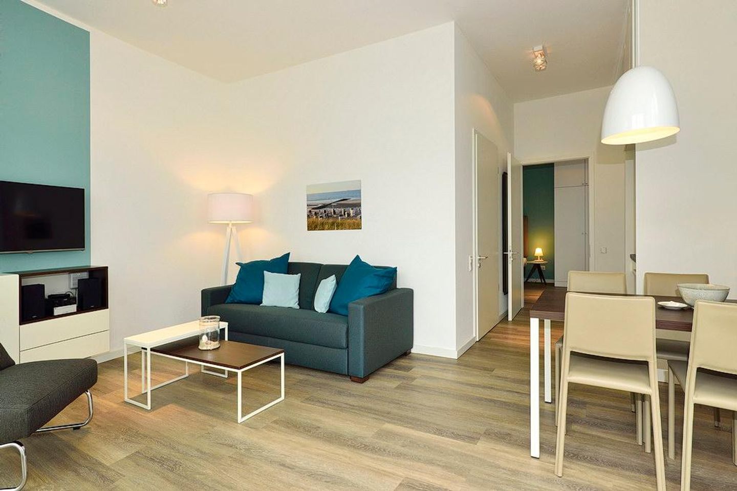 Aparthotel Anna Düne Aparthotel Anna Düne 0-08 Wangerooge - Wohn/ Essbereich mit Couch, Fernseher und Esstisch