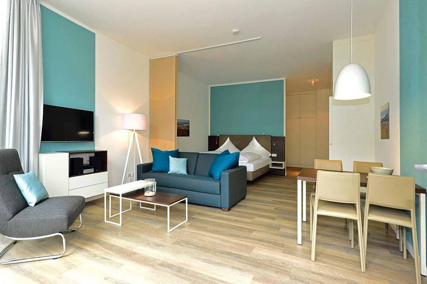 Aparthotel Anna Düne Aparthotel Anna Düne 0-11 Wangerooge - Wohn/ Essbereich mit Couch, Fernseher und Esstisch