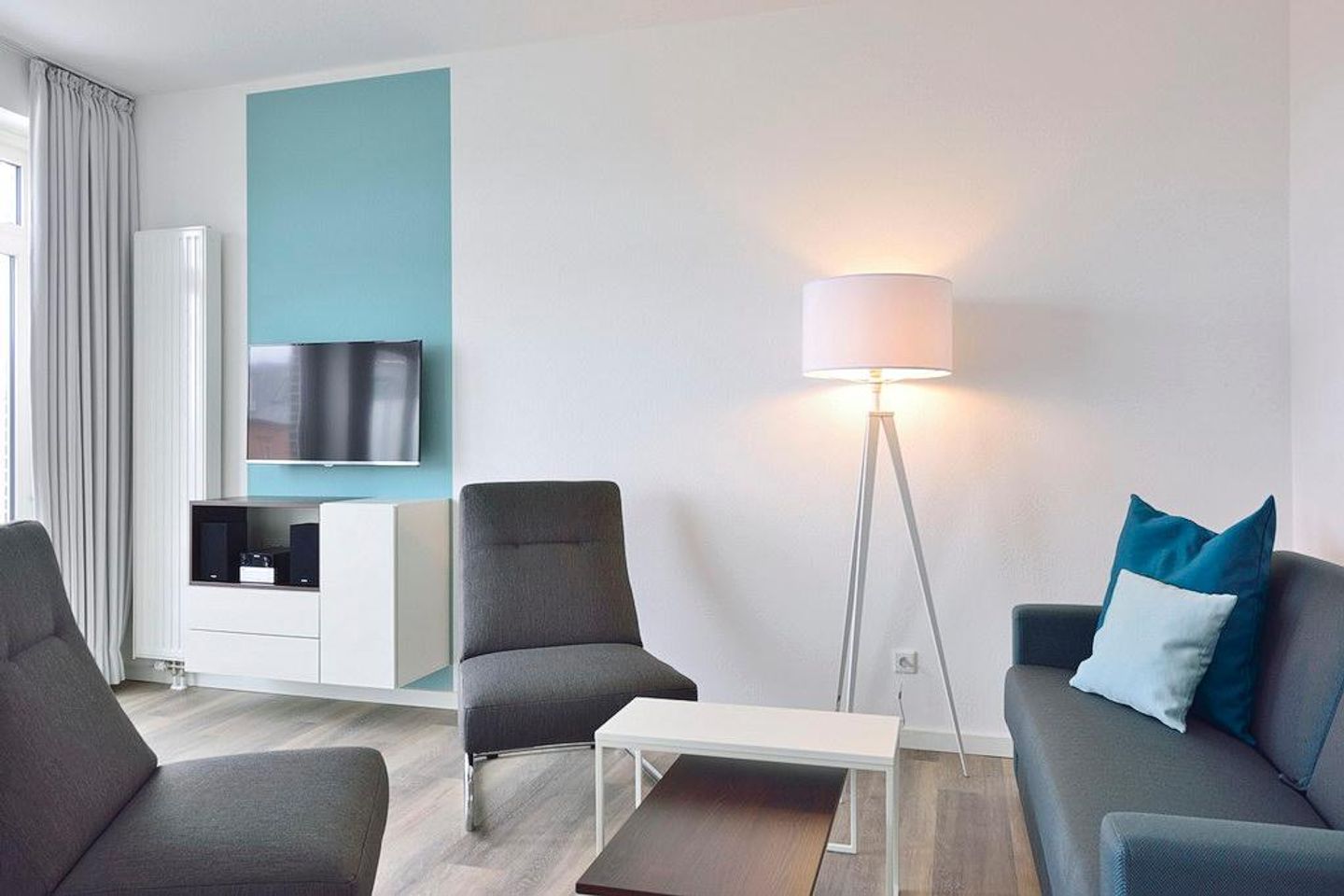 Aparthotel Anna Düne Aparthotel Anna Düne 1-13 Wangerooge - Wohn/ Essbereich mit Couch, zwei Sessel und Fernseher