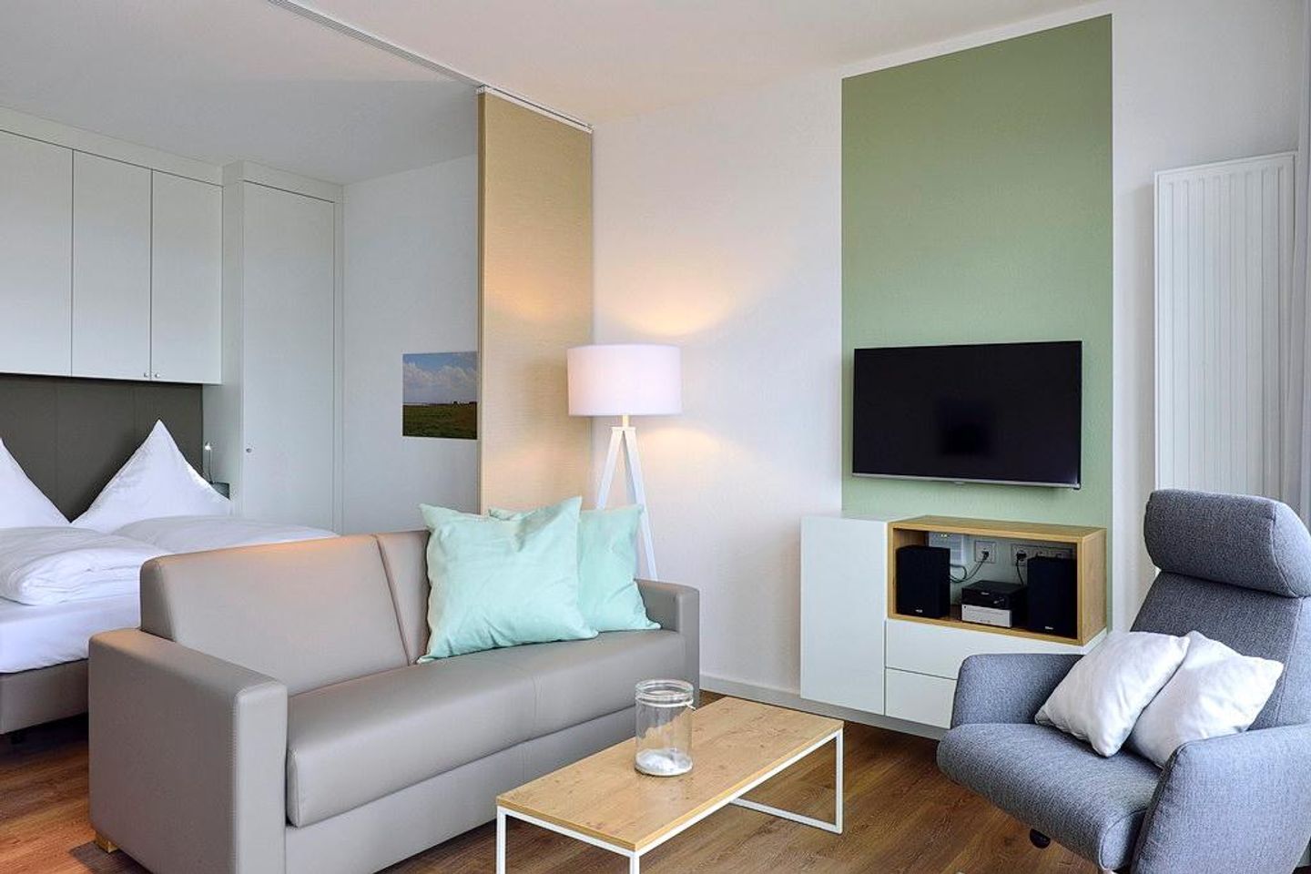 Aparthotel Anna Düne Aparthotel Anna Düne 1-15 Wangerooge - Wohn/ Essbereich Couch, Tisch und Fernseher