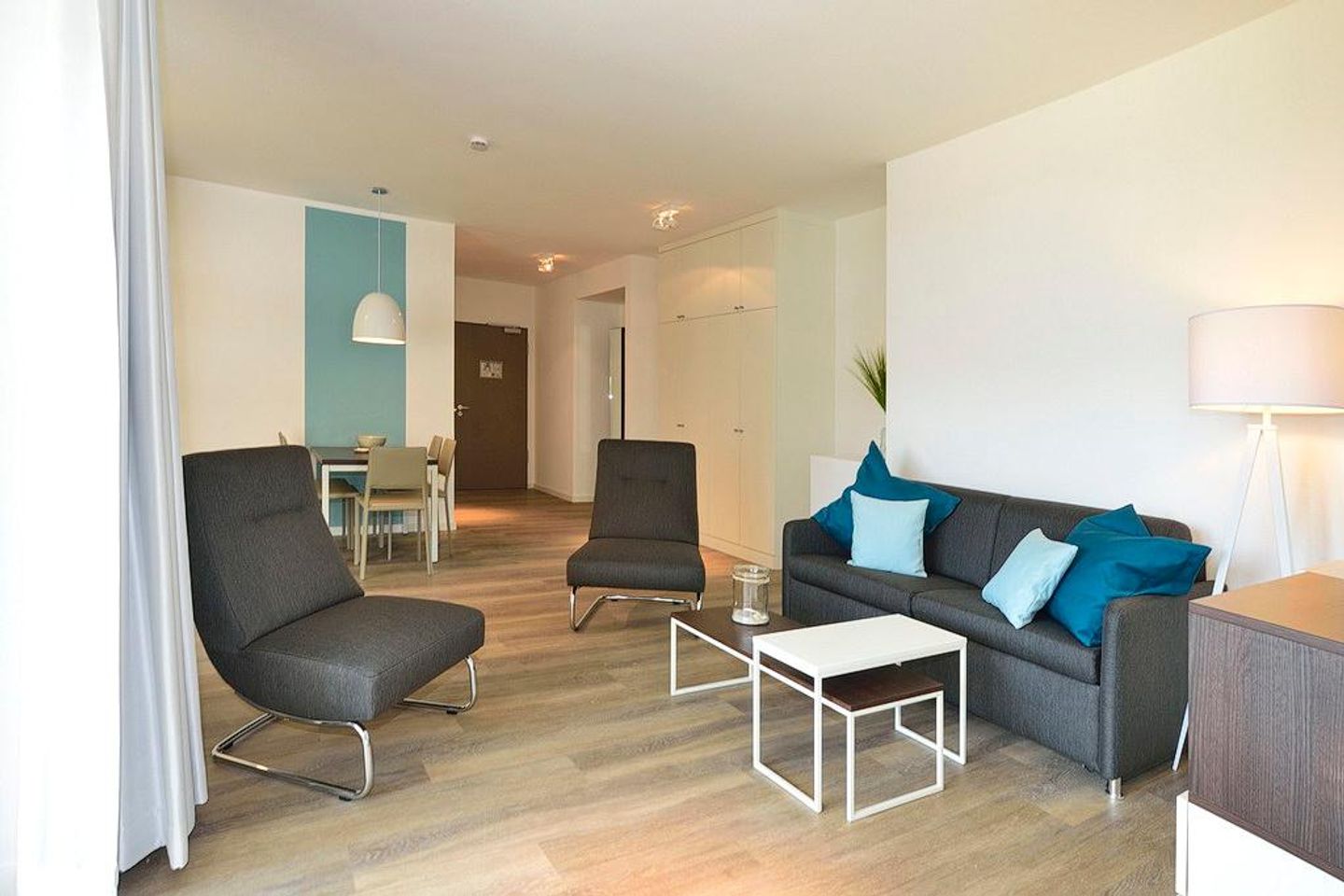 Aparthotel Anna Düne Aparthotel Anna Düne 1-25 Wangerooge - Wohn/ Essbereich mit Couch, zwei Sessel und Tisch