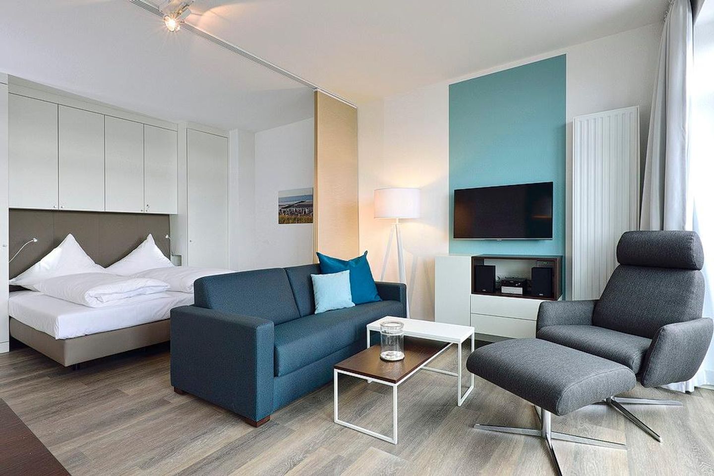 Aparthotel Anna Düne Aparthotel Anna Düne 2-30 Wangerooge - Wohn/ Essbereich mit Couch und Fernseher