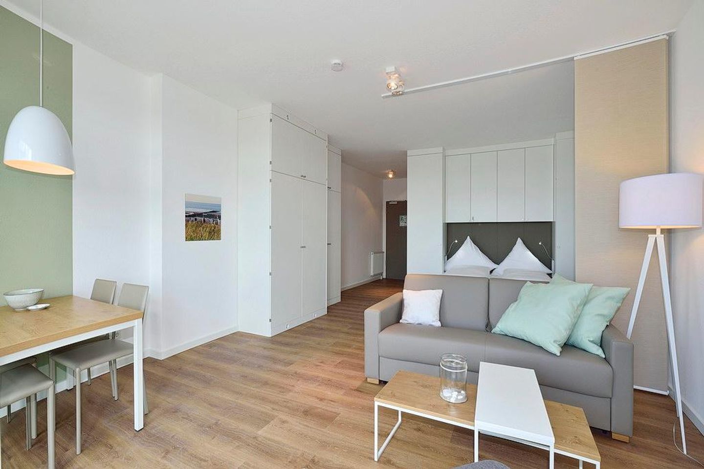 Aparthotel Anna Düne Aparthotel Anna Düne 2-32 Wangerooge - Wohn/ Essbereich mit Couch und Esstisch