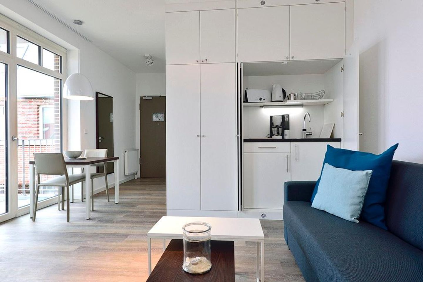 Aparthotel Anna Düne Aparthotel Anna Düne 2-40 Wangerooge - Wohn/ Essbereich mit Couch, Küchenzeile und Esstisch