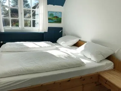 Schlafzimmer mit Doppelbett in der Ferienwohnung Reetblick in Norddorf auf Amrum Haus Pesel Ferienwohnung *Reetblick*