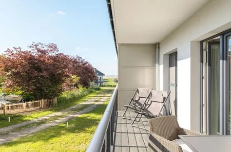 Ferienwohnung Lüttstuv Ostseebad Wustrow – sonniger Balkon mit gemütlichen Sitzmöbeln und Blick ins Grüne  Lüttstuv