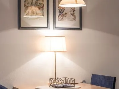 Ferienwohnung Bernstein Zingst – Stilvoller Essbereich mit Wandbildern und warm beleuchteter Tischlampe  Bernstein