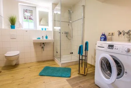 Badezimmer mit Dusche und Waschmaschine  Ferienwohnung im Landmannsheim