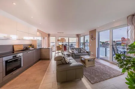 ChatGPT:  Ferienwohnung Garzini Hafenresidenz Waren (Müritz) – Offener Wohnbereich mit moderner Küche  Garzini