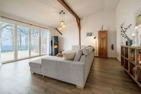 Offenes Wohnzimmer mit Couch, Meerblick, Ofen und Essbereich Westscheune am Mühlendamm