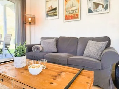 Wohnzimmer mit Couch, TV und Holzofen Fördezauber