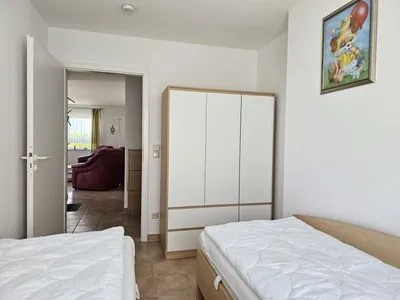 Schlafzimmer mit Einzelbetten und Kleiderschrank Residenz am Strand Wohnung 4-56