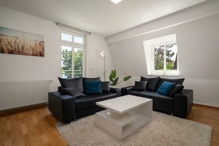 Apartment Strandglück Malchow - Wohnzimmer mit schwarzem Sofa  Strandglück
