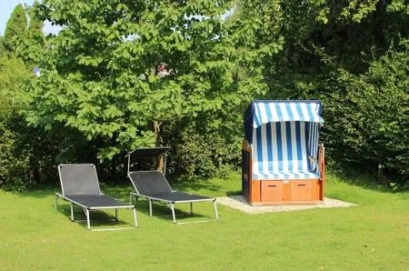 Genießen Sie entspannte Stunden auf dieser großzügigen Terrasse mit Liegen und Strandkorb. Haus Schiffchen