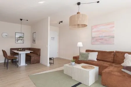 Ferienwohnung Küstenglück Aparthotel Zingst - Wohnzimmer mit Blick zur offenen Wohnküche  Küstenglück