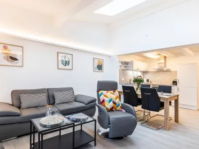 Wohn/Essbereich: Sofa, Sitzbereich, Essbereich, smartTV, Zugang zum Balkon mit Insektenschutztür, hoher Raum mit Dachfen FeWo Ausblick in PRORA - 8.52